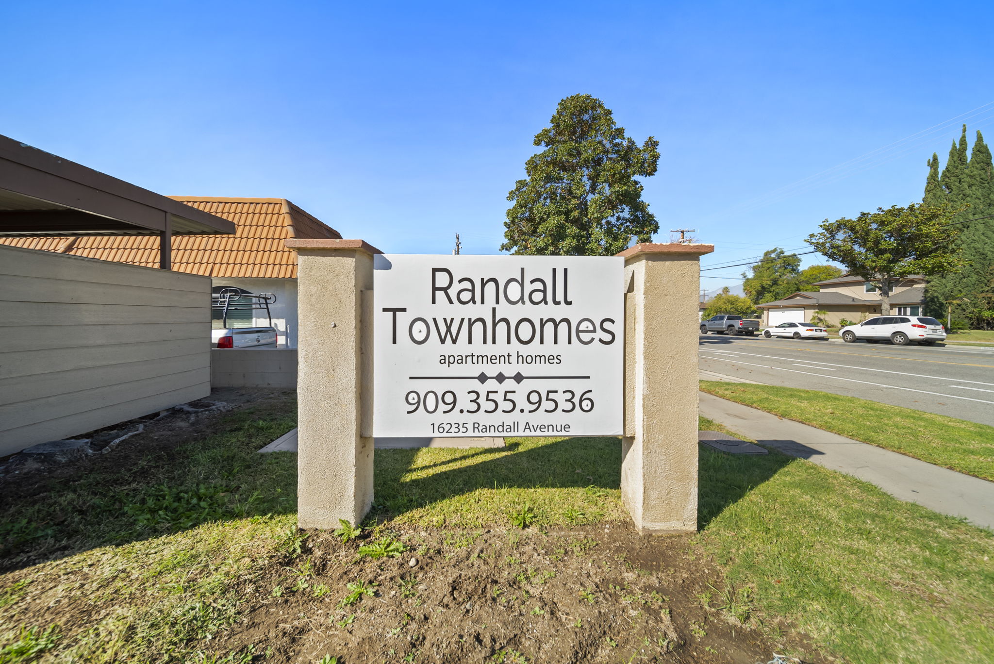 A sign for Randall Townhomes stands in front of a building.